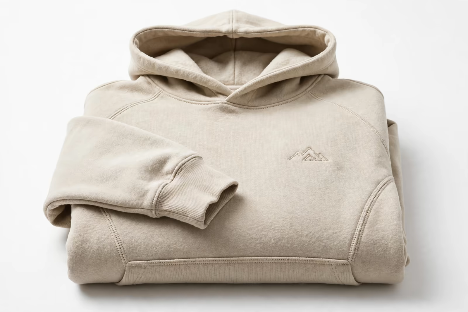 A premium folded pullover hoodie with a small tonal embroidered emblem on the chest, produced by a clothing manufacturer in Bangladesh